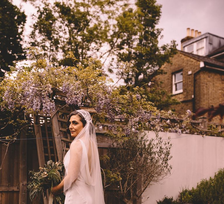 vintage inspired bridal look with bride in a satin wedding dress with puddle train and long Juliet cap wedding veil 