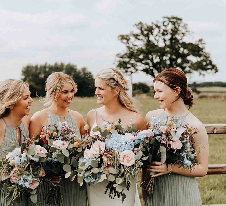 Sage green bridesmaid dresses with pastel bouquets