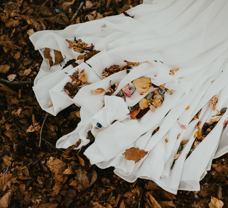 Train of brides white wedding dress with dried leaves at late summer wedding in Norfolk