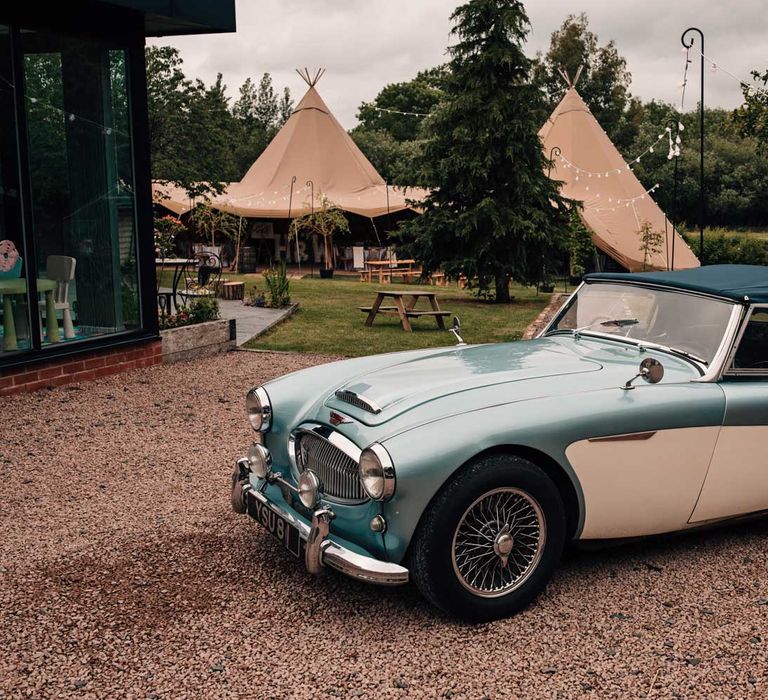 Blue and white vintage wedding car with soft top for tipi wedding reception