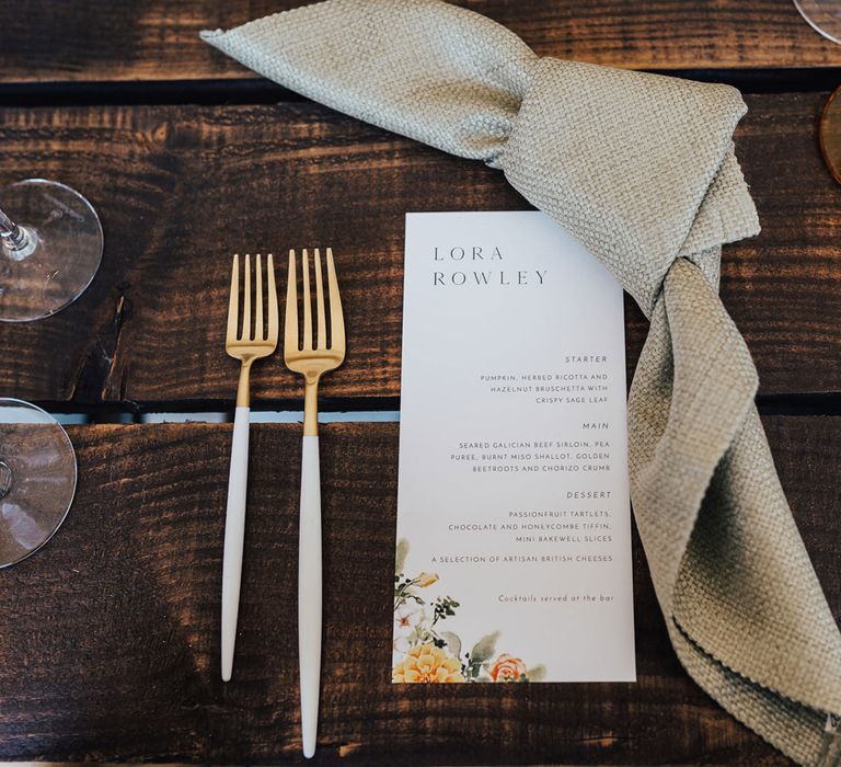 Wedding menu with floral illustration, textured napkin and gold cutlery for rustic wedding reception