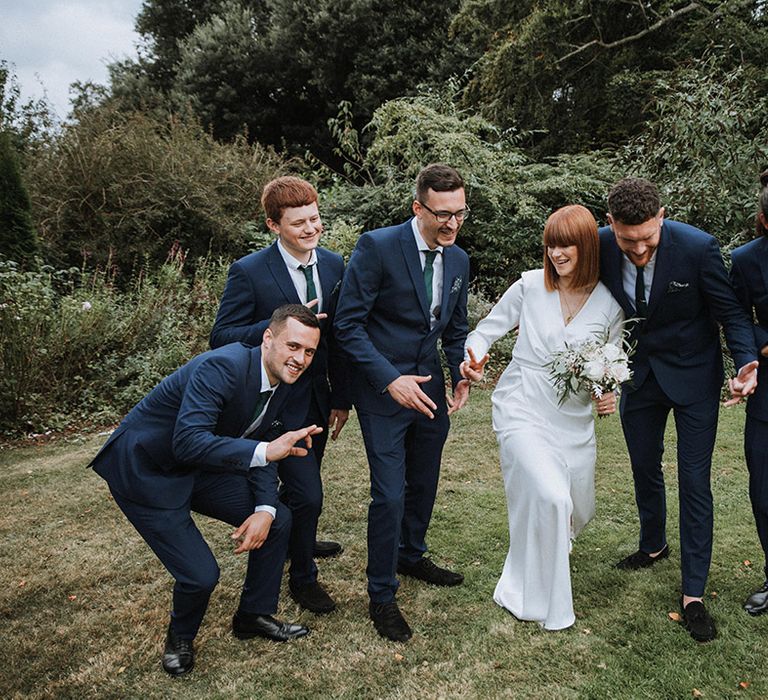 Bride in long sleeve wedding dress with brides men in matching suits