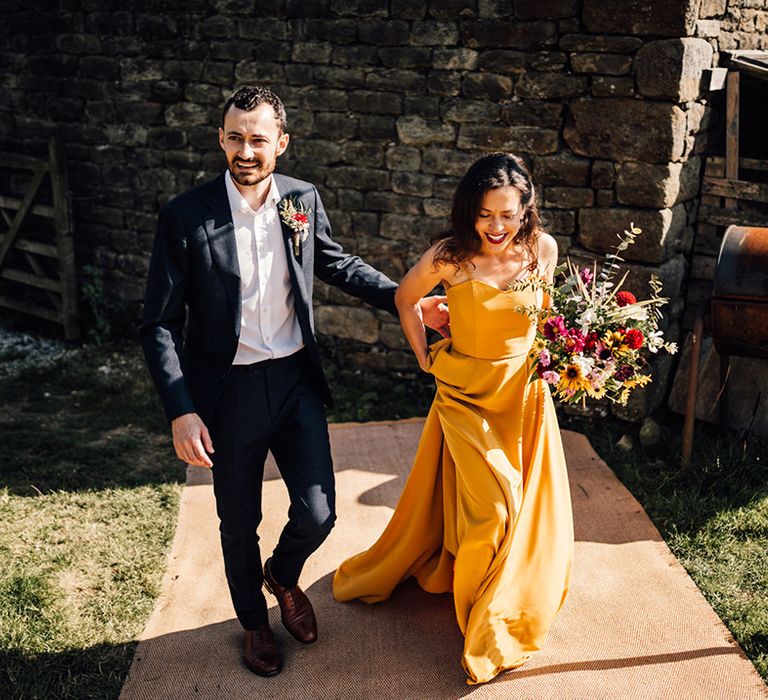 Bride & groom walk together outdoors