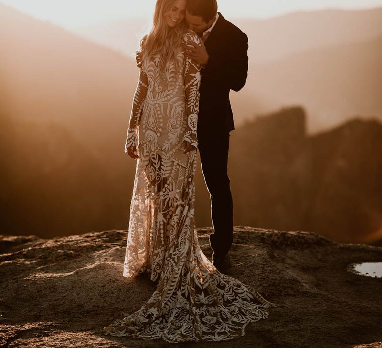 Bride & groom embrace on mountain