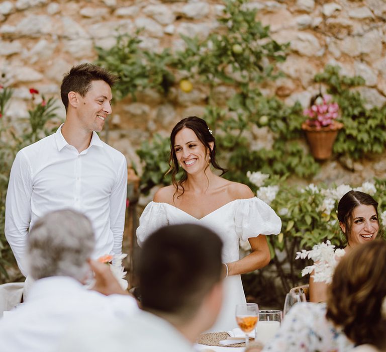 Bride and groom smile for speeches