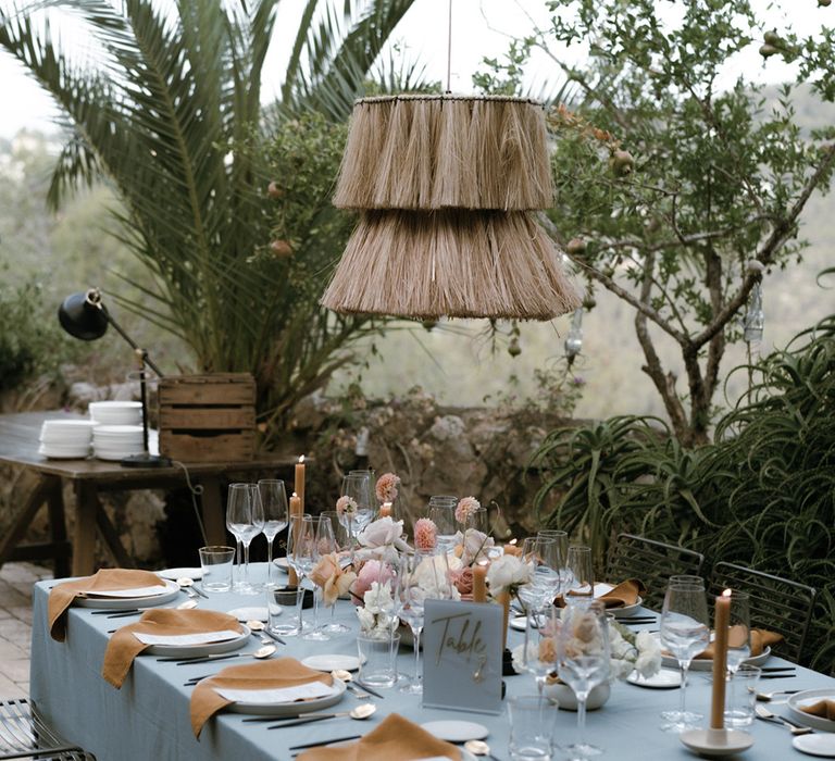 Tablescape with grey tablecloths and mustard coloured candles and napkins and acrylic sign with gold font for table numbers 