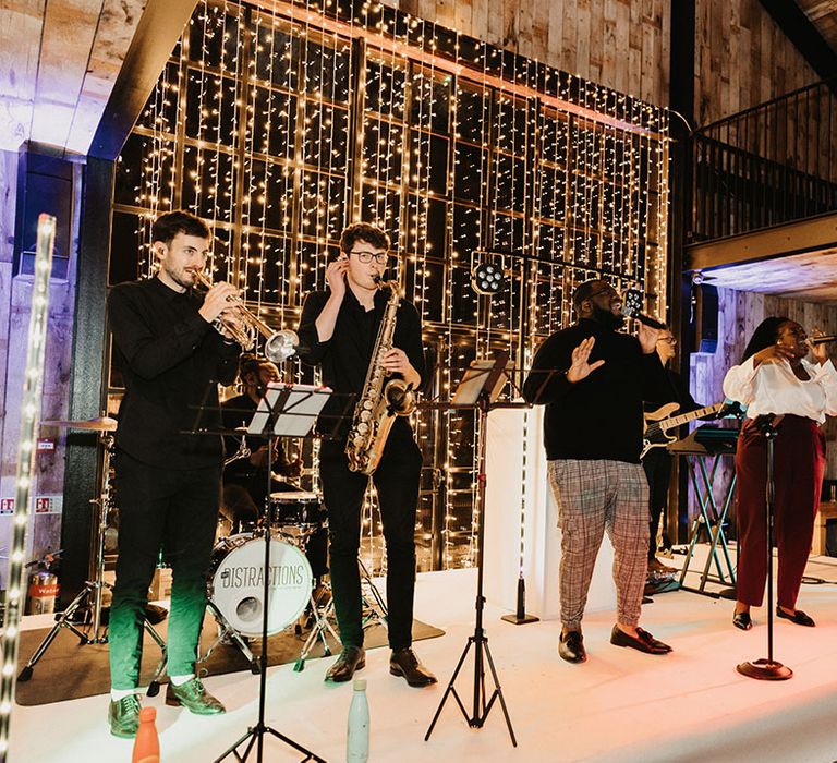 Live wedding band entertainment for winter wedding with fairy lights backdrop