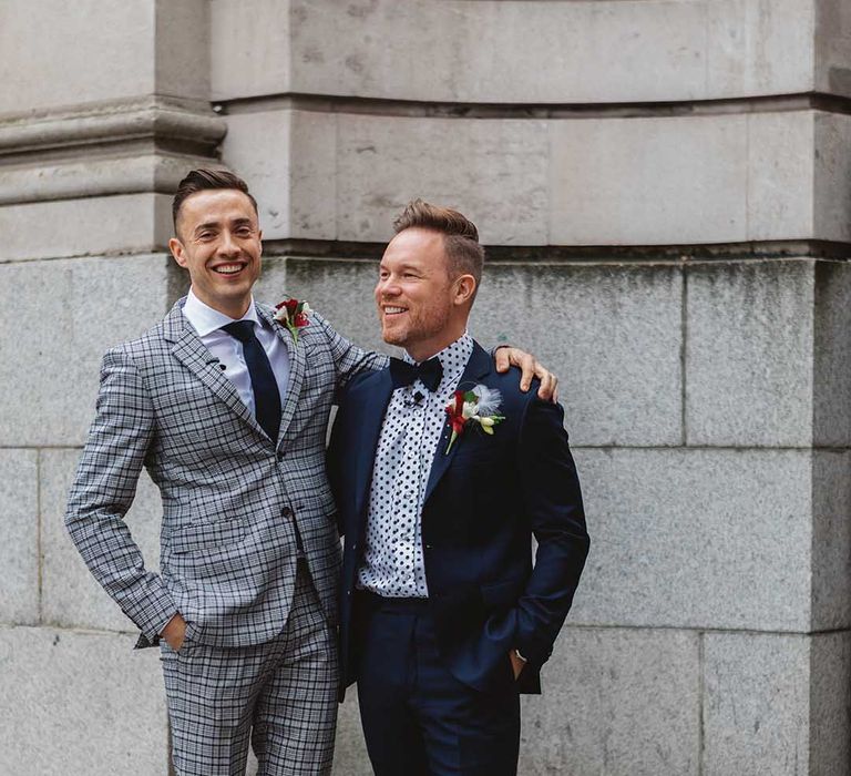 Grooms stand with one another wearing gay wedding suits for Chelsea Old Town Hall wedding