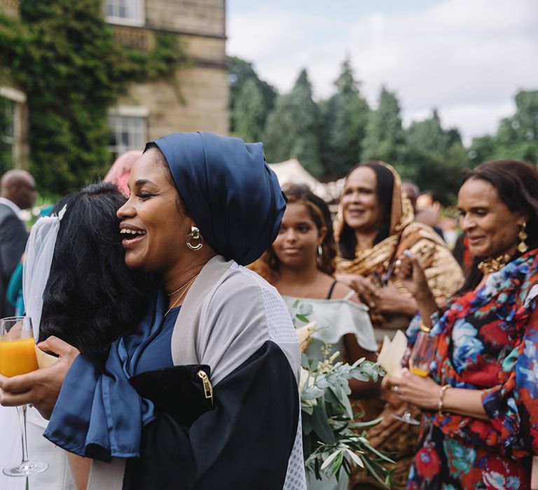 Bride hugs wedding guest at outdoor wedding at Middleton Lodge