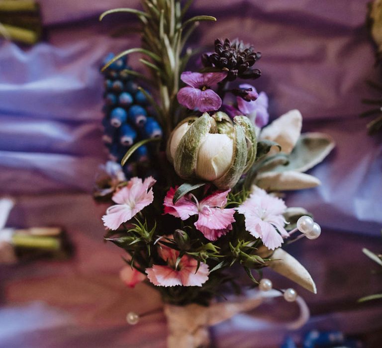 Pink, purple and blue flowers for groom's boutonnière with pearl pins