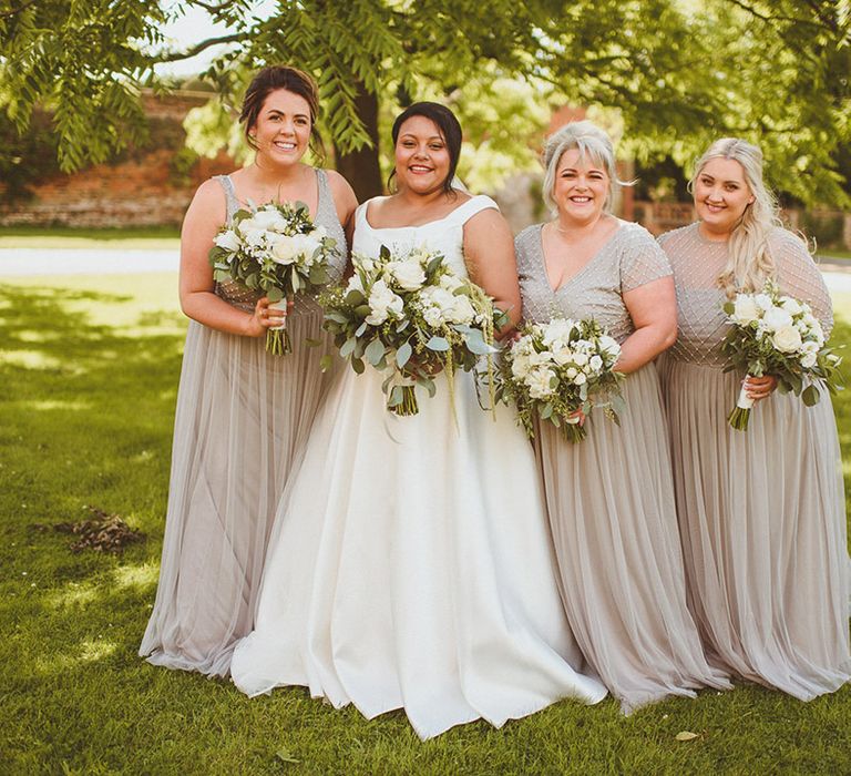 Bridesmaids in grey sparkly top and tulle skirt dresses with bride in bardot style wedding dress for country house wedding 