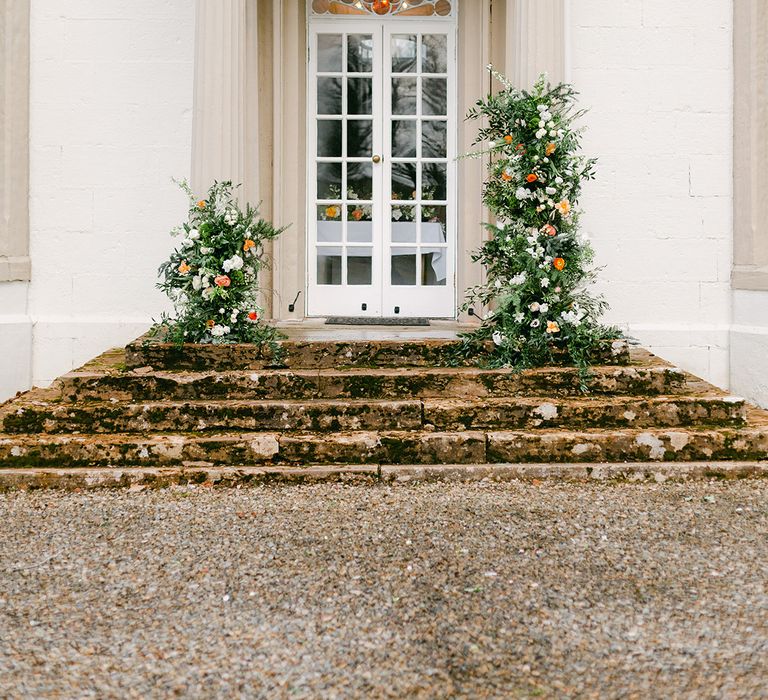 French door at Holesfoot decorated with green, white and peach column flower arrangement 