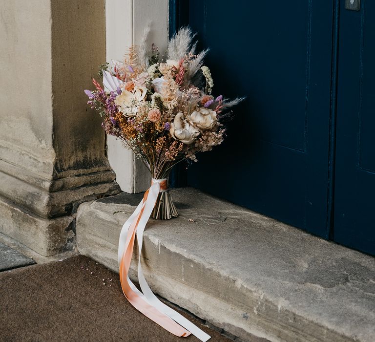 dried and preserved pastel flowers wedding bouquet tied with ribbon 