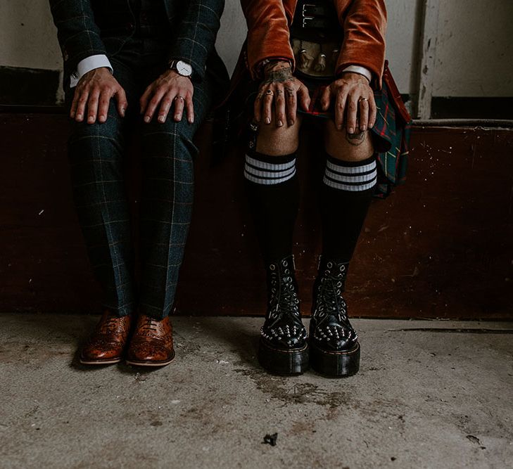 Groom wearing brogues next to his groom wearing platform studded Dr Martens and high socks