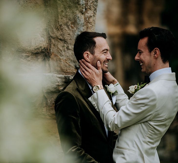 Groom leans in to kiss his groom outdoors at Birdsall House 