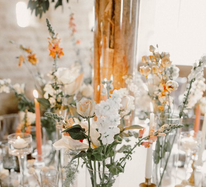 wedding table decor with coloured goblets and flower stems in vases 