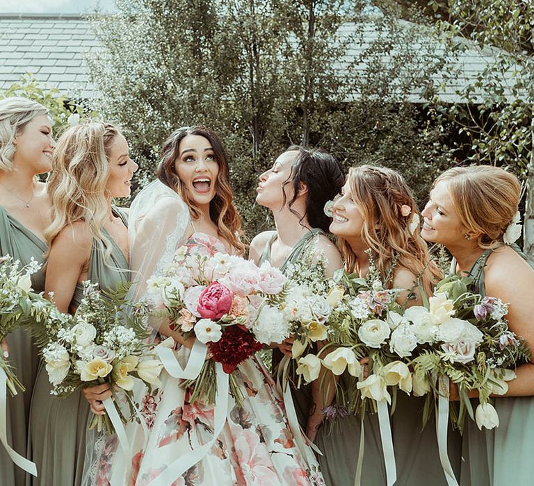 Bridesmaids in green bridesmaid dresses holding pink flowers with the bride for the wedding at Farbridge 