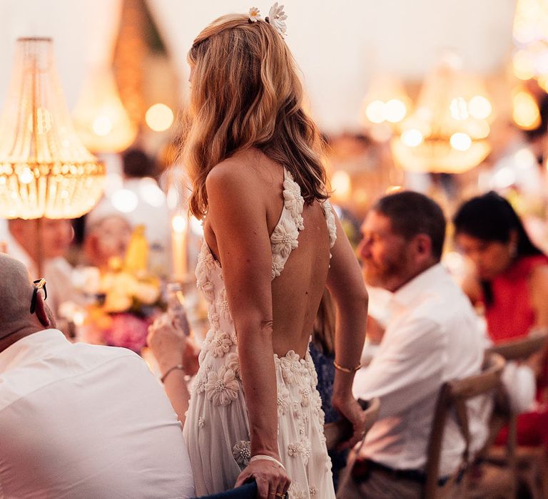 Bride wears flower hair accessories to match her flower halter neck style wedding dress