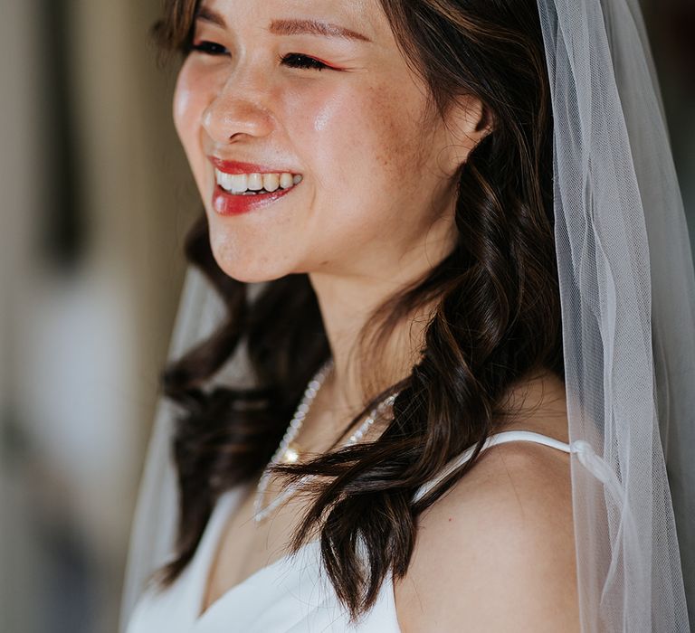 East Asian bride wears pale pink lipstick orange eyeliner 