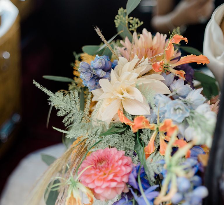 Colourful bridal bouquet finished with green foliage 