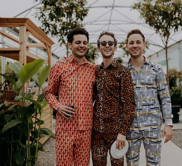 Three guests wearing bright and patterned shirts and trousers