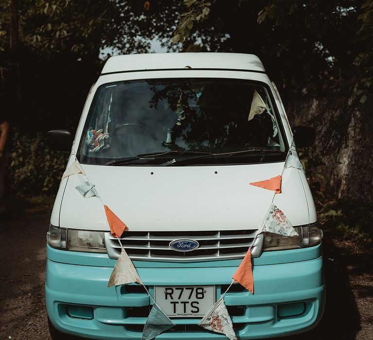 Blue and white vintage Ford van wedding transport decorated with bunting for the fun festival wedding 