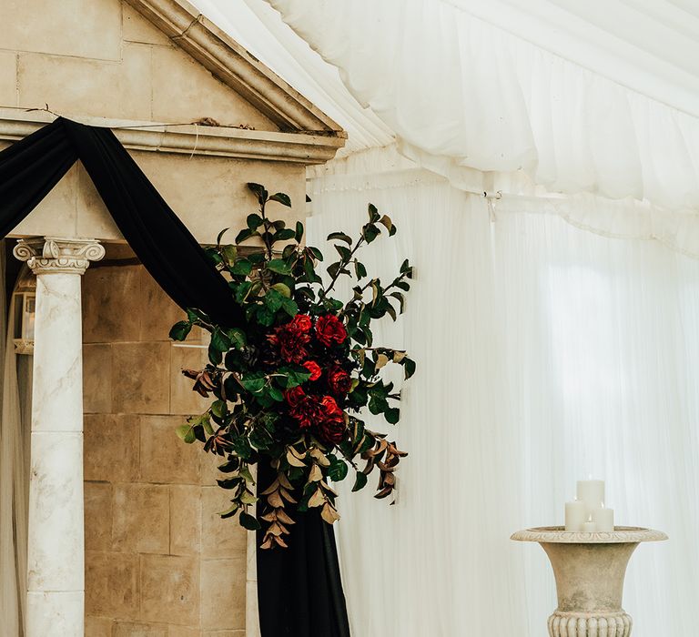 Black wedding drapery with red rose bush wedding flowers decorating the wedding altar at Parley Manor wedding 