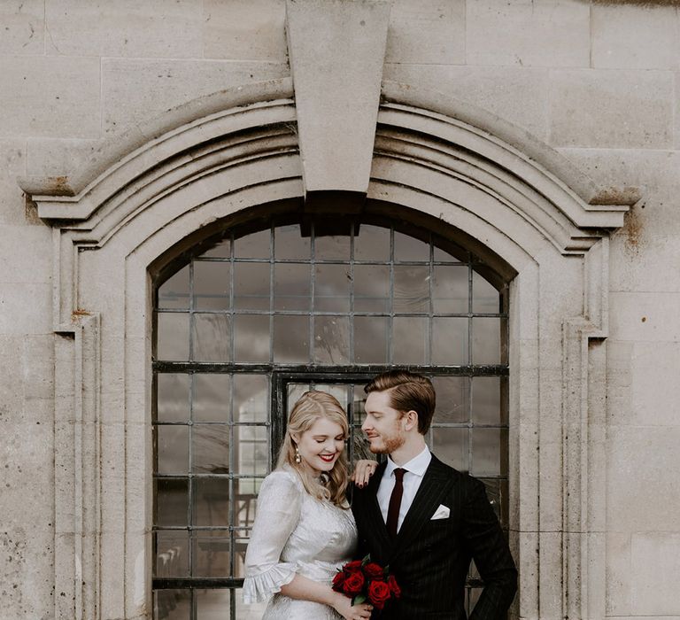 Gothic Halloween wedding with the bride in a metallic silver wedding dress with the groom in a black tie suit 