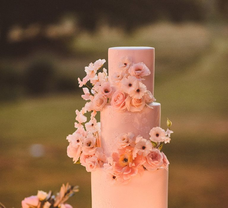 Three tier classic iced wedding cake with floral cake decorations for outdoor wedding 