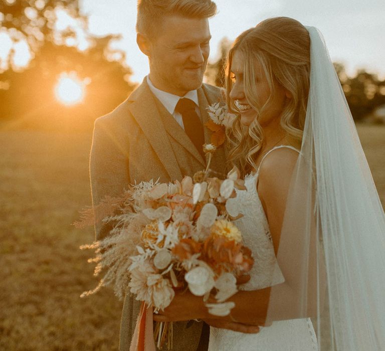 A beautiful golden hour portrait of the bride and groom at sunset at St Tewdrics House wedding venue in Wales 