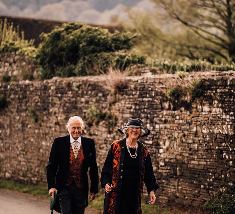 The grandparents arriving at the wedding in matching orange wedding outfits 