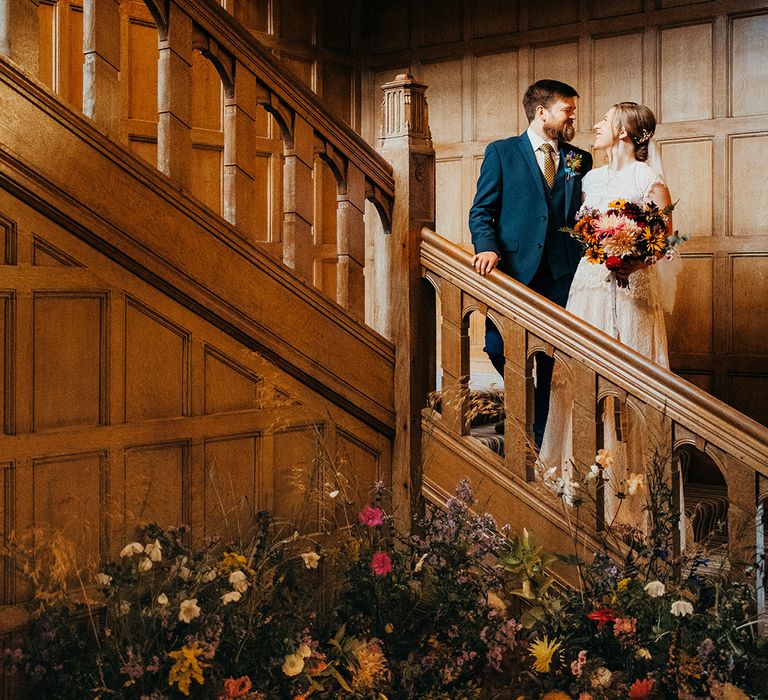 Sustainable eco conscious wedding at Coombe Lodge with the bride and groom standing on stairs 