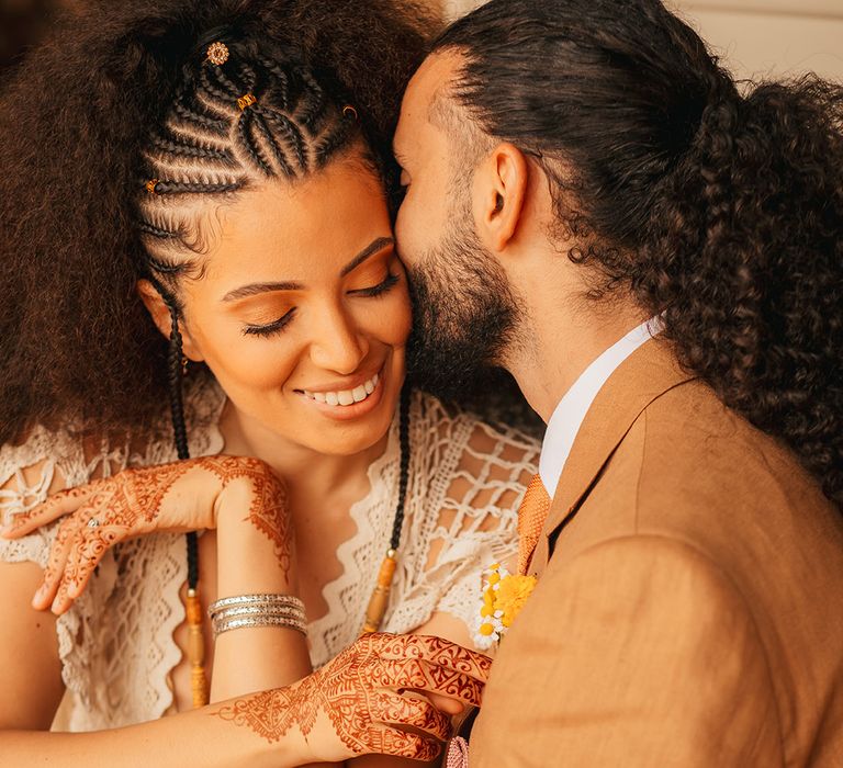 Bride with braided wedding hair with henna in crochet gown from Poppy Perspective with the groom in a brown linen suit 