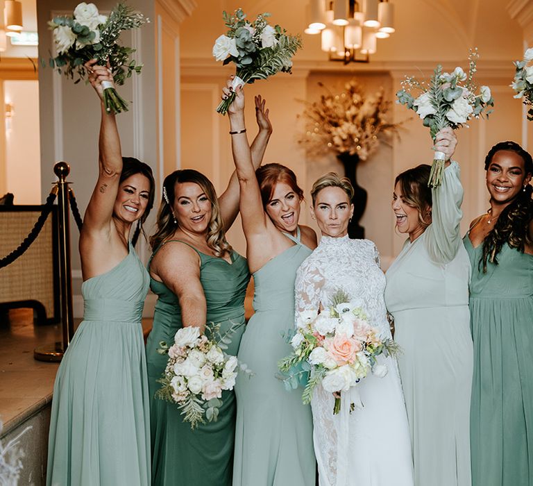 Bridal party wearing different shades of green bridesmaid dresses for traditional country house wedding 