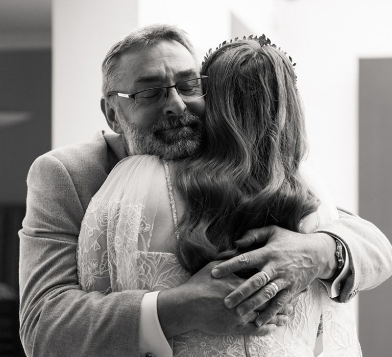 Father of the bride embraces the bride for sweet wedding photo on the morning of the wedding 