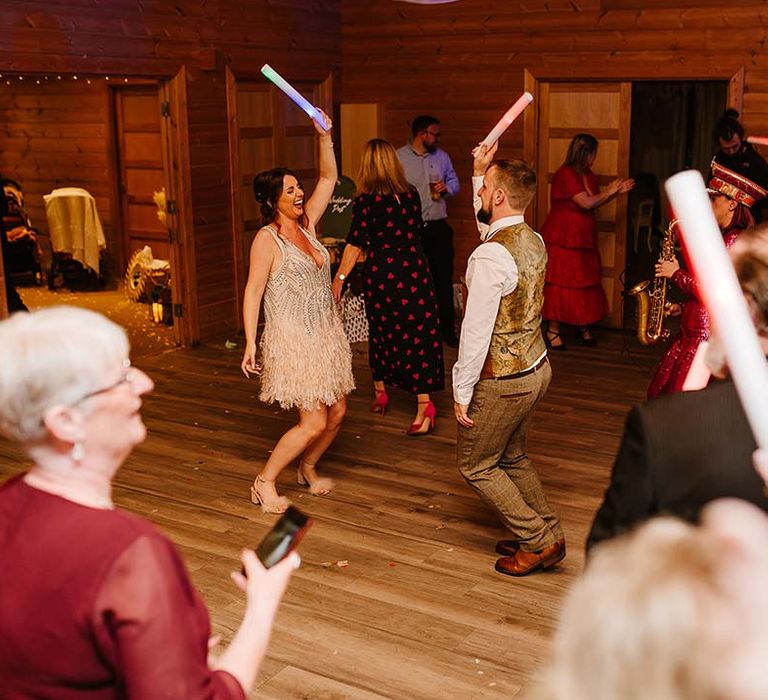 The bride and groom dance at their wedding reception with glow sticks 