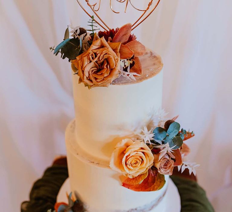 Two tier white frosted wedding cake with personalised heart shape wedding cake topper for boho wedding 