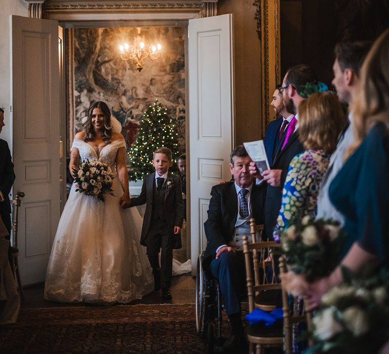 Bride walking down the aisle with her son at the country house wedding 