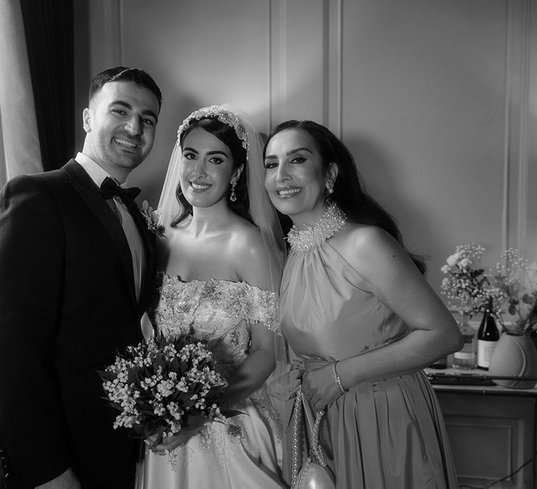 Bride smiles with her parents as they get ready for the wedding day 