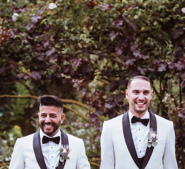 Two grooms in matching black and white monochrome wedding suits for their interfaith gay wedding 