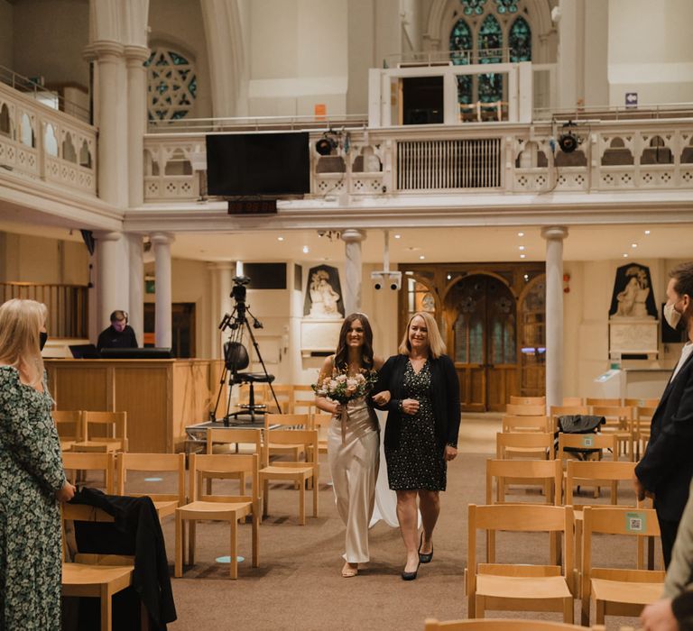 Mother of the bride walking her daughter down the aisle 