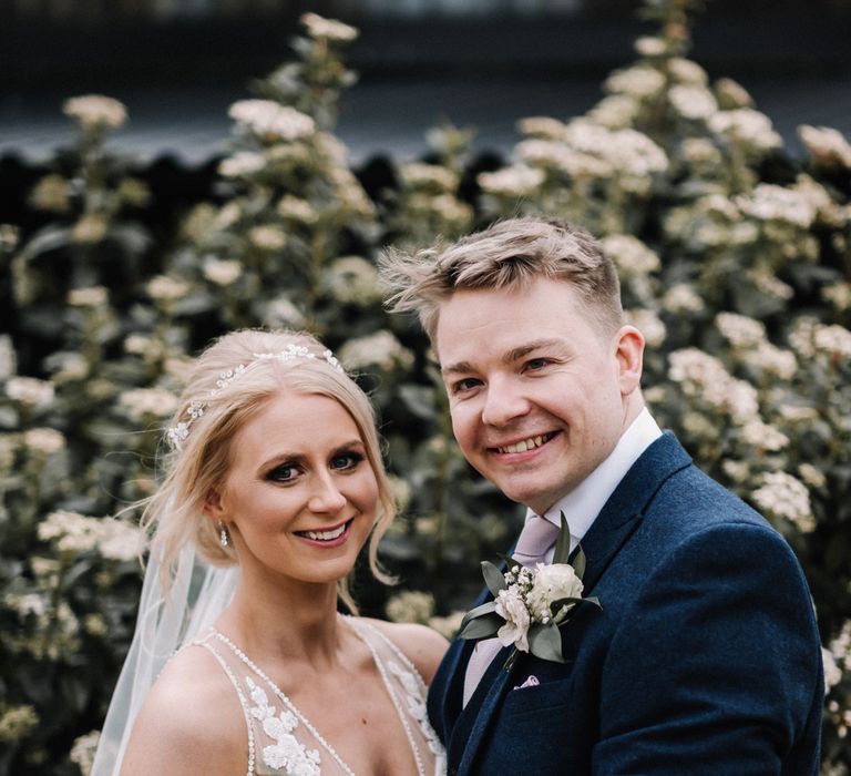 Happy couple on their wedding day with pink roses