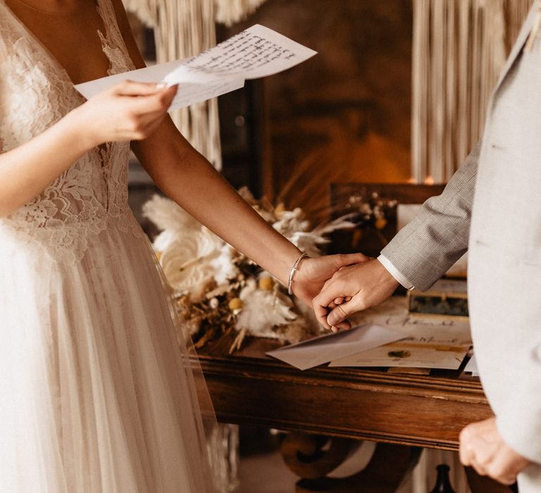 Bride and Groom reading vows and holding hands