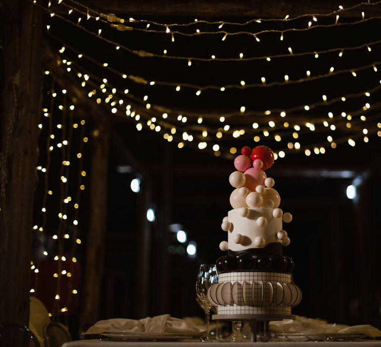 Abstract three tier wedding cake with geometric shapes and 3D white and red ball decorations