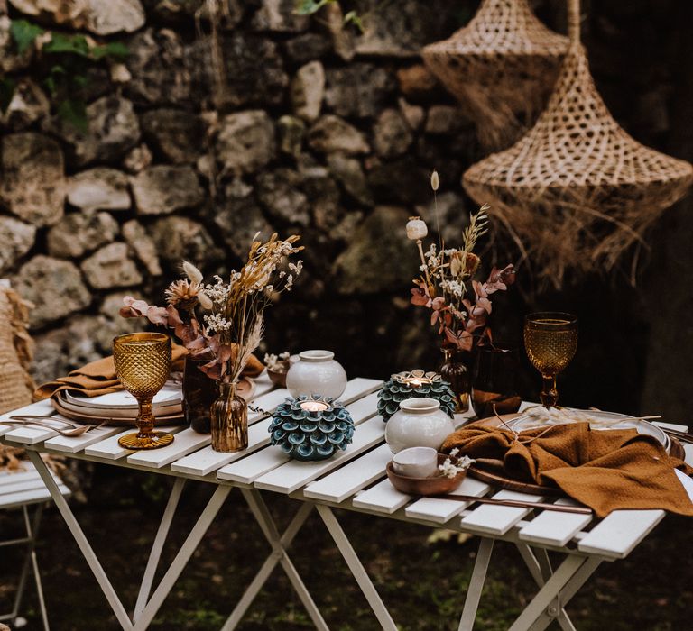 Outdoor table setting with wicker lampshades hanging