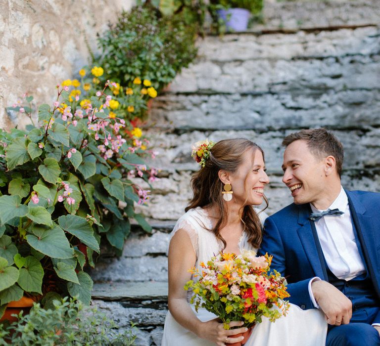 The bride and groom smiling on the steps of Valeni Boutique Hotel