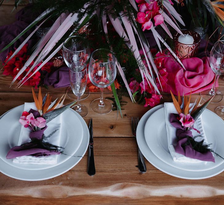 Pink and purple table set up at wedding with pink palm leaves. Photography by Stephanie Shenton. 