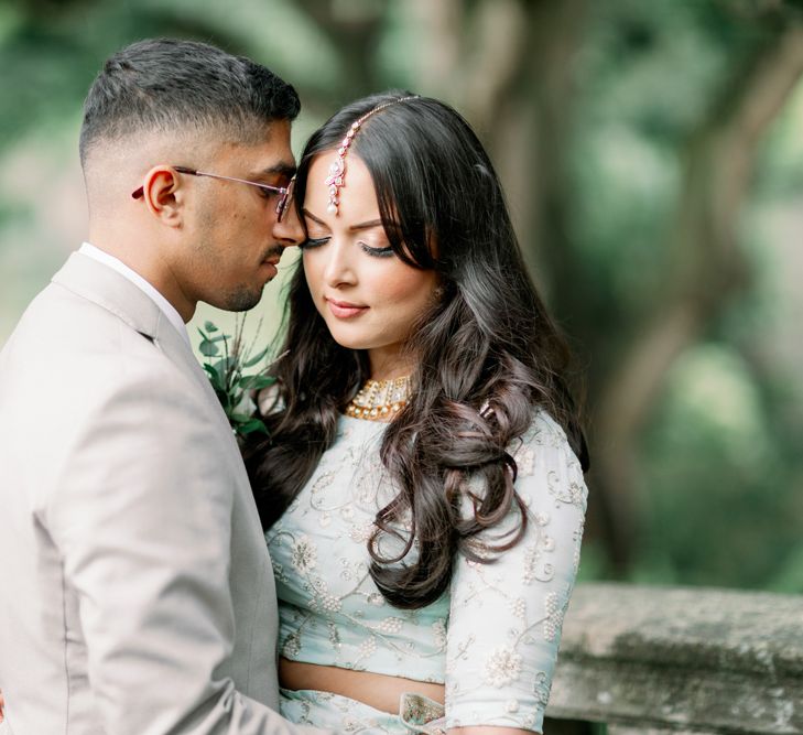 Intimate bride and groom portrait with Muslim bride in a mint sari and Sikh groom in a beige suit 