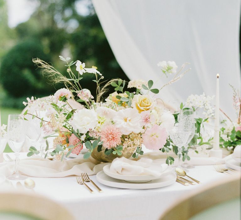 Romantic spring floral centrepiece of roses, carnations and chrysanthemums for English garden party wedding