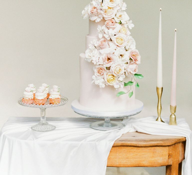 Four tier white wedding cake with cascading rose floral decoration by Mon Annie Cakes